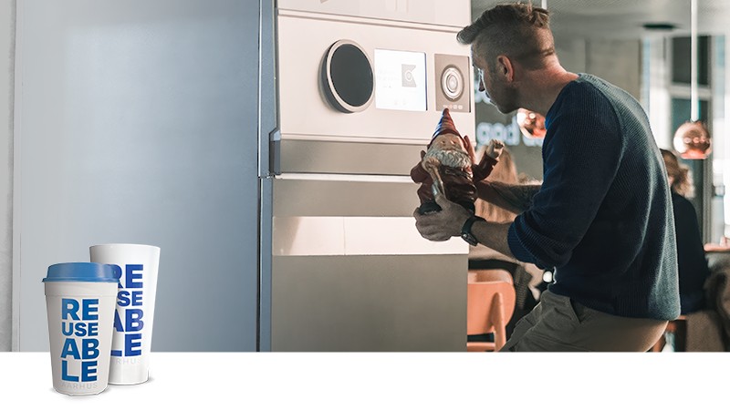 reusable cup logo and man holding garden gnome